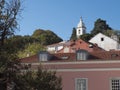 View of pink house and church bell tower at Alfama at Santa Maria Maior district, Lisbon, Portugal. Blue sky background