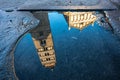 View of Pistoia Cathedral (Cattedrale di San Zeno) bell tower reflected in a puddle, Tuscany, Italy