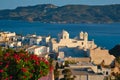 View of Plaka village on Milos island over red geranium flowers on sunset in Greece Royalty Free Stock Photo