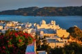 View of Plaka village on Milos island over red geranium flowers on sunset in Greece Royalty Free Stock Photo