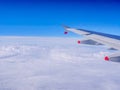 View from a plane window: a plane wing over clouds and blue sky Royalty Free Stock Photo
