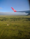 View from the plane window to the African green fields with trees