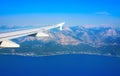 View from the plane on the wing sea and land Royalty Free Stock Photo