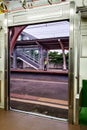View of platform through open sliding doors from inside of an empty commuter train car stopped at Railway Station Royalty Free Stock Photo
