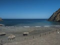 View of Playa de Vallehermoso, volcanic black sand beach with pebbles and sun umbrellas beautiful bay with blue ocean Royalty Free Stock Photo