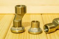 View plumbing tools brass pipe connectors on wooden board close up