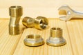 View plumbing tools brass pipe connectors on wooden board close up
