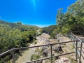 View point with metal bar barrier looking down Honey Creek where it tumbled over Bridal Veil Falls upstream of Turner Falls with Royalty Free Stock Photo