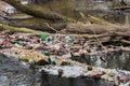 View of the polluted small forest river with a lot of different plastic garbage. Environment pollution problem