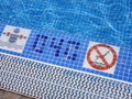 A view of the pool edge with specified depth for safe swimming and a warning sign prohibiting diving.