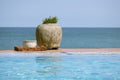 View with pool by the sea and the large stone vase with the plant