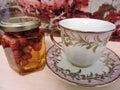 View of porcelain cup and honey with nuts on the table