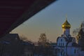 View from the porch of a wooden house on the old white church with a golden dome. Royalty Free Stock Photo