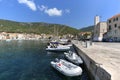 View on port on Adriatic Sea, moored boats and old citadel, island Vis, Komiza, Croatia