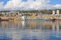 View of the port in Croatia, the city of Rijeka, blocks by the sea, high blocks, built-up coast, white thick clouds, cranes in the