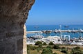 View on a port and yacht parking on blue sky and sea water background through big aged brick wall arched tower window Royalty Free Stock Photo