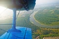 A view of the porthole of a turboprop biplane on the river.