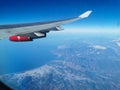 View from the porthole on the wing of an airplane with a red aircraft engine flying to Cyprus in the morning over beautiful Royalty Free Stock Photo