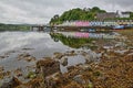 View of Portree harbor with reflections and colorful houses, seen from the seashore, Isle of Skye, Highlands, Scotland, UK