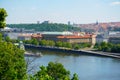 View of Prague with river Vltava with ships and amazing buildings with red roofs.