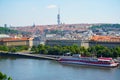 View of Prague with Vltava with ships and amazing buildings with red roofs.