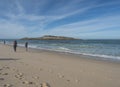 View of Praia da Ilha do Pessegueiro sand beach with group of hikers, ocean waves and Fort of Pessegueiro small island