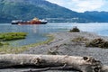 Shoreline of Old Town Valdez Alaska. Log in foreground. Commerical ship in background unidentifiable