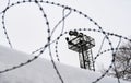 View on prison guarding tower through barbed wire Royalty Free Stock Photo