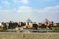 View of the pyramids of Keops, Kefren and Menkaure from the ring road of Cairo. Ahead half-built homes