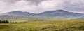 A view of Quirang hiils in the distance from the walking path from Staffin village to Staffin harbour and An Corran Beach Royalty Free Stock Photo