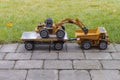 View of Radio Controlled model excavator, dump truck and trailer on background. Children and adults concept.