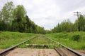 View from railroad crossing to abandoned rail track overgrown with grass in Russia Royalty Free Stock Photo