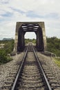 View of railway and old steel bridge with green tree at the left and right side of railway,blue sky and clouds on background Royalty Free Stock Photo