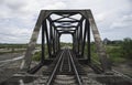 View of railway and old steel bridge with green tree at the left and right side of railway,blue sky and clouds on background Royalty Free Stock Photo