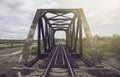 View of railway and old steel bridge with green tree at the left and right side of railway,blue sky and clouds on background