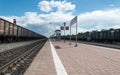 View of the railway tracks from the station platform. Cars standing on the tracks. Freight car. Railway station with a platform. T