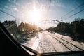 View of the railway of a train with snow around them in a beautiful day with the sun in the sky. Traveling by train in a snowy and