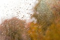 View of Rain drops on window with green,red and yellow color tree in background Autumn Abstract blurred Backdrop Royalty Free Stock Photo