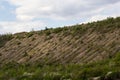 View ravine covered with greenery. Landscape valley with geological faults. Earthen mountains and bumps relief on against sky.