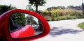 View of rear car in side mirror of red cabriolet at speed Royalty Free Stock Photo