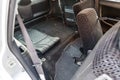 A view through the rear passenger seats inside the cabin of a Japanese station wagon to the roomy trunk with a black rubber mat