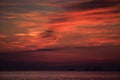 view of red fleecy clouds before sunrise sea on foreground Royalty Free Stock Photo