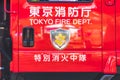 View of a red Japanese fire truck door with ideograms signifying TOKYO FIRE DEPARTMENT and firemen`s emblem with the coat of arms