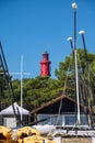 View on red lighthouse Le Phare du Cap Ferret, Arcachon Bay with many fisherman\'s boats and oysters farms near , Cap Ferret