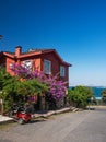 View of the red old house on the island of Kinaliada with a blooming garden by electric bike. Adalar Islands