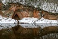 view of red sandstone cliffs, sunny winter day, reflections in the river