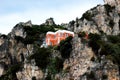 View of a red and white building with lighthouse perching on a cliff in the Amalfi coast