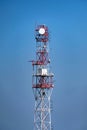 View of red and white communication tower against blue sky Royalty Free Stock Photo