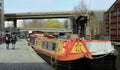 View of the regent canal with houseboats, locals, and visitors in London, England