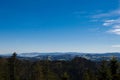 View of regular ordinary view from the mountain peak to green hills with a beautiful blue sky